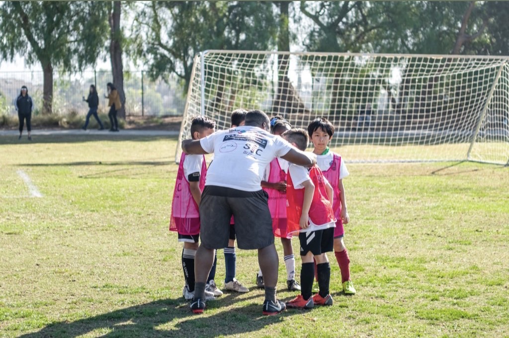 Players listen to guidance from a coach