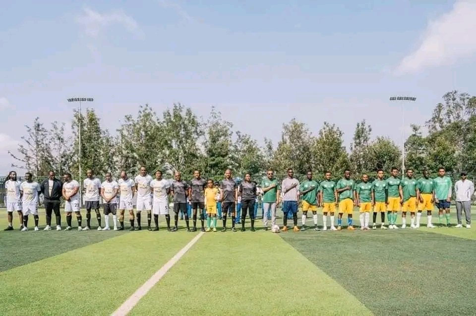 Players and participants lined up together before a friendly football match